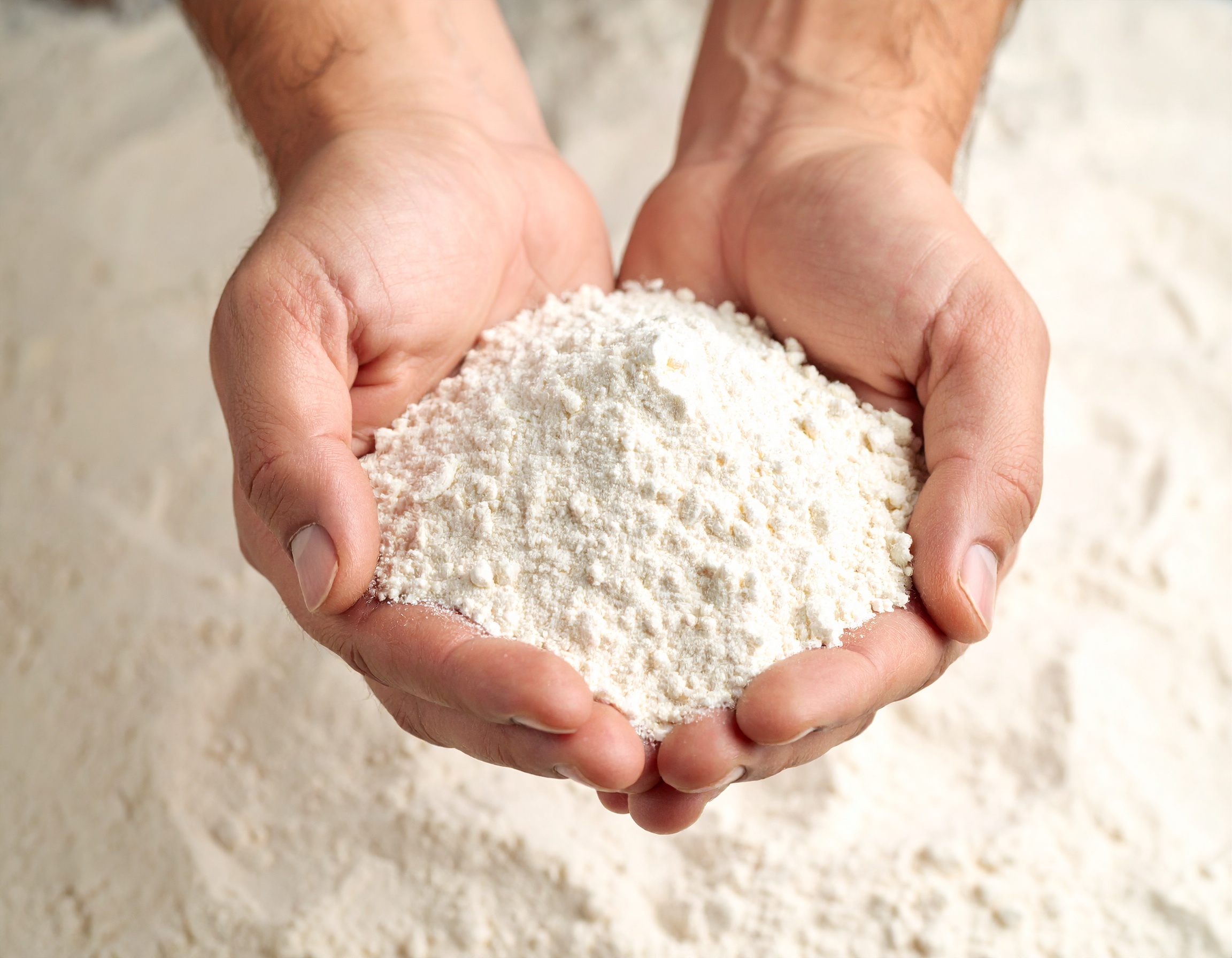 Two hands holding flour